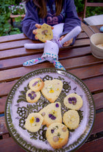 Load image into Gallery viewer, Heart-shaped cookies with floral decorations on a decorative plate outdoors.